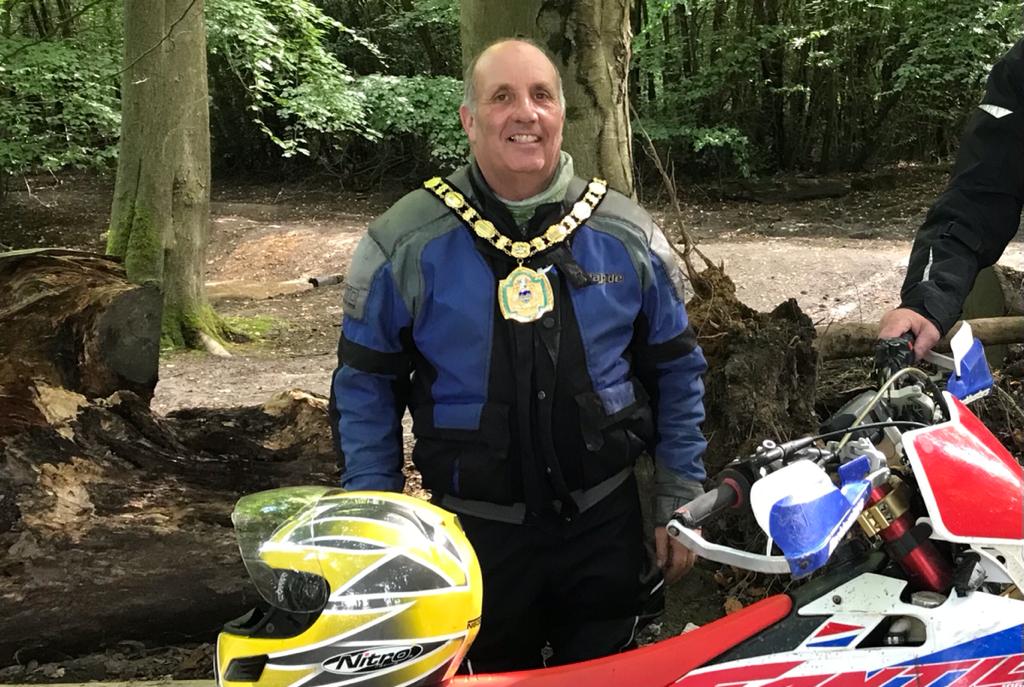 Cllr Paul Potter, chair of mole valley district council standing in front of his motor bike.